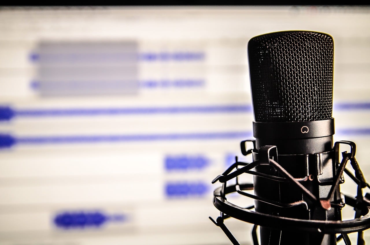 Micrófono de estudio de grabación con programa de edición al fondo