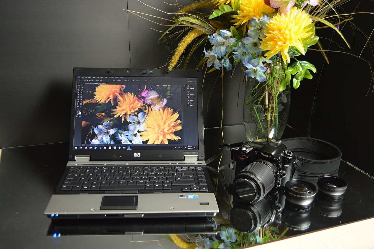 Portátil con programa de edición de imagen abierto para retocar fotografía de flores