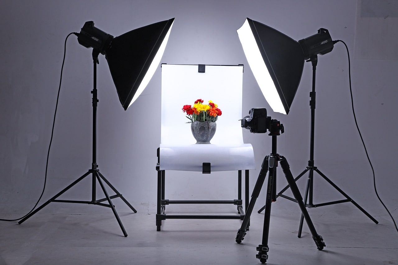 Estudio de fotografía con varios focos dirigidos a una maceta con flores